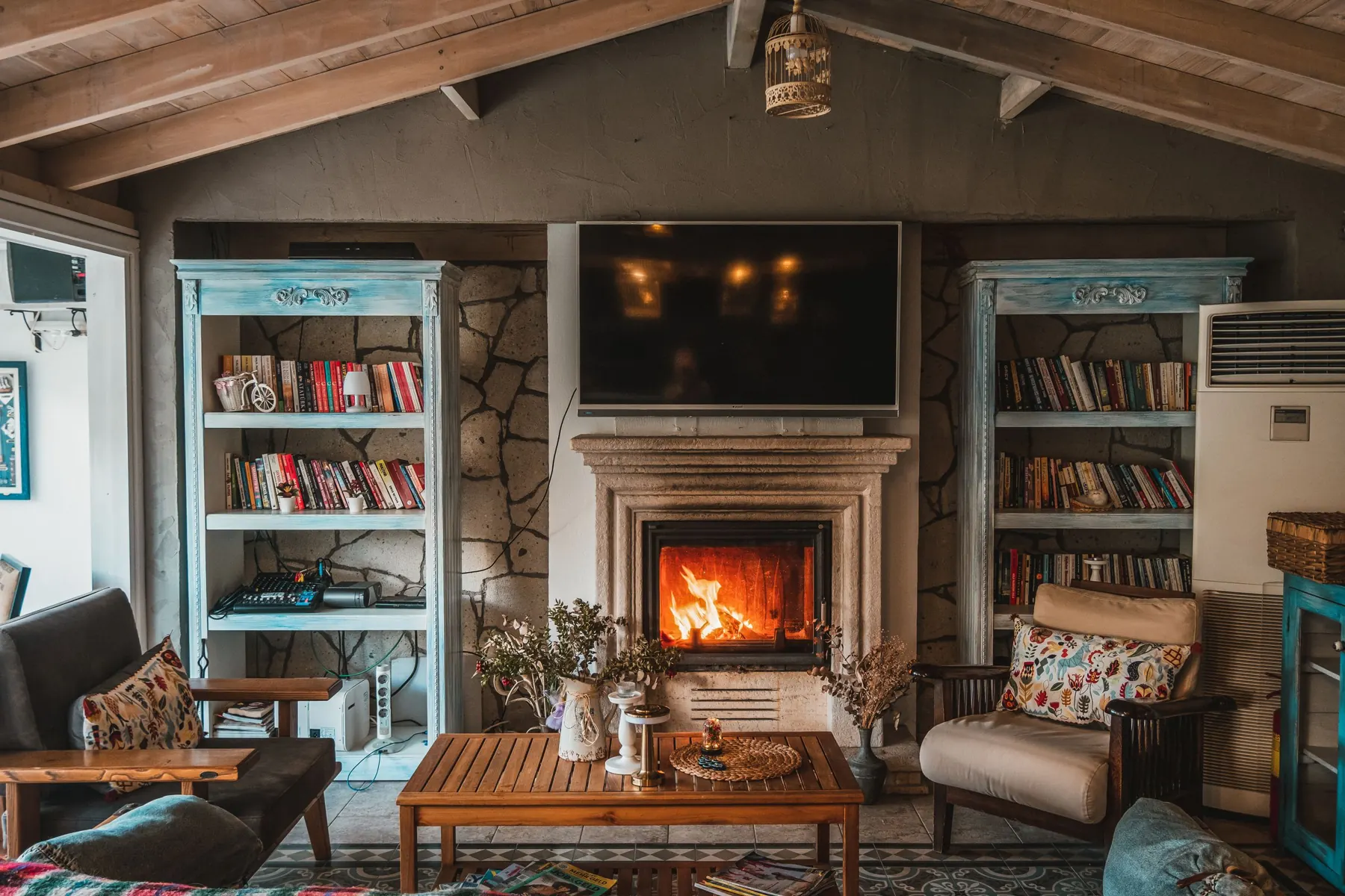 Living room with a lit fire and bookshelves either side