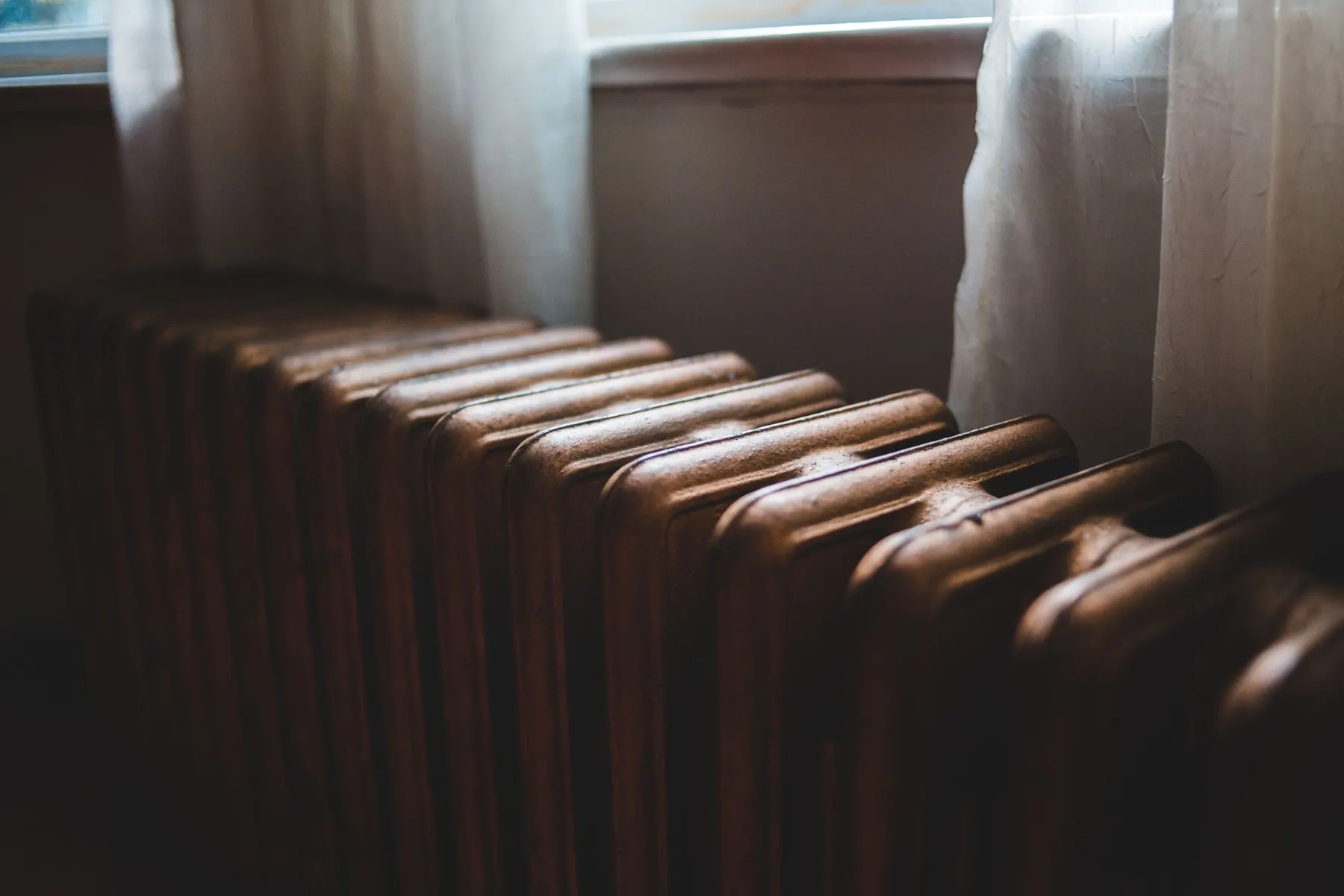 Old cast iron radiator in warm sunlight